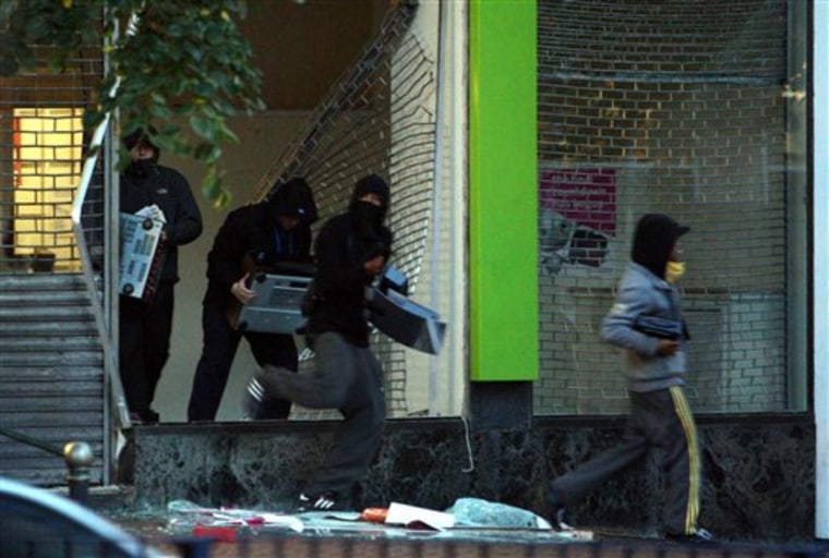 Youths run from an electronics store in Birmingham, England, on Aug. 9. As Britain comes to grips with the causes of the past week's descent into anarchy, Prime Minister David Cameron has identified the growth of gangs as a key factor and is recruiting high-profile American anti-gang experts to help bring them to heel.